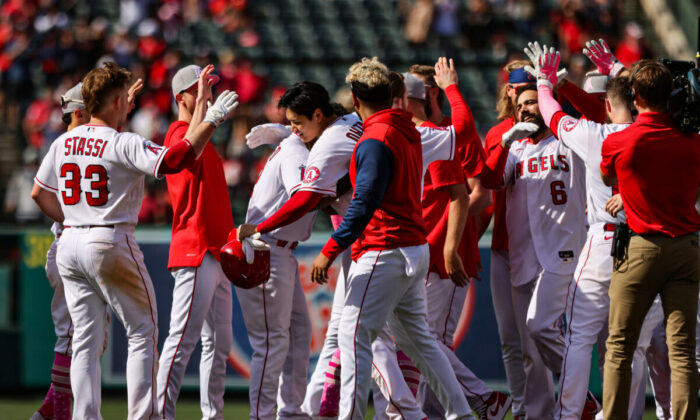 The Los Angeles Angels celebrate a 5-4 win against the Washington Nationals. Shohei Ohtani centered holding helmet, and Anthony Renden #) at Angel Stadium of Anaheim, in Anaheim, on May 8, 2022. (Katharine Lotze/Getty Images)