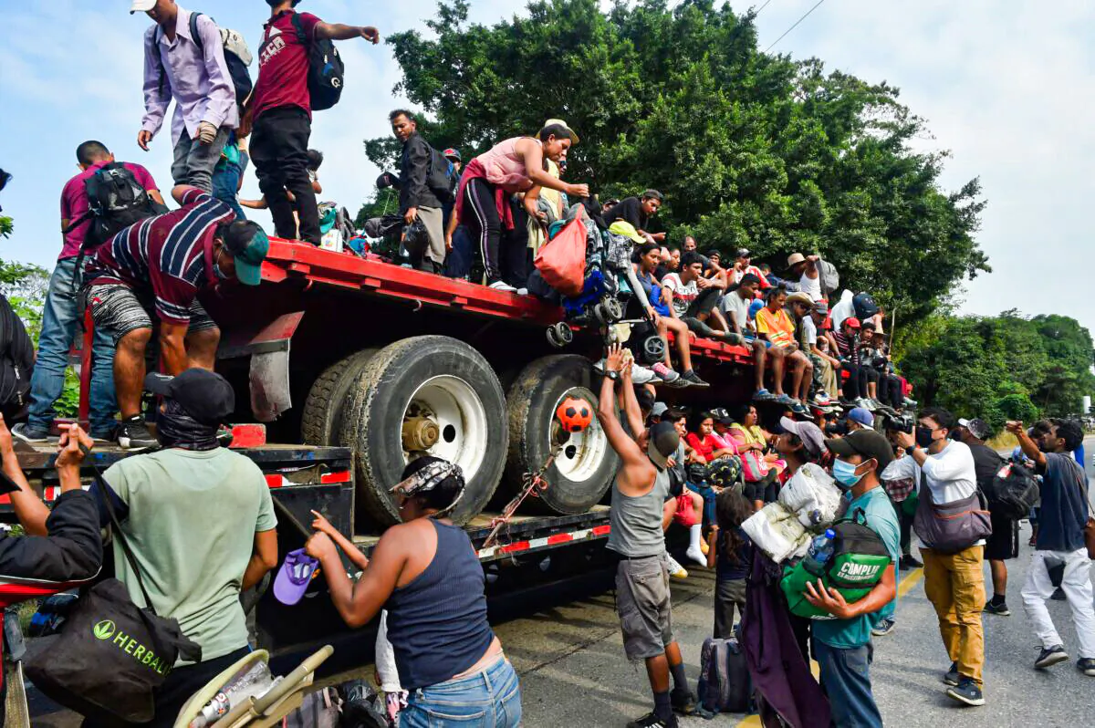 Migrants who were heading in a caravan to the United States get off a truck in Nuevo Morelos, Jesus Carranza municipality, Veracruz state, Mexico, on Nov. 17, 2021. (Claudio Cruz/AFP via Getty Images)