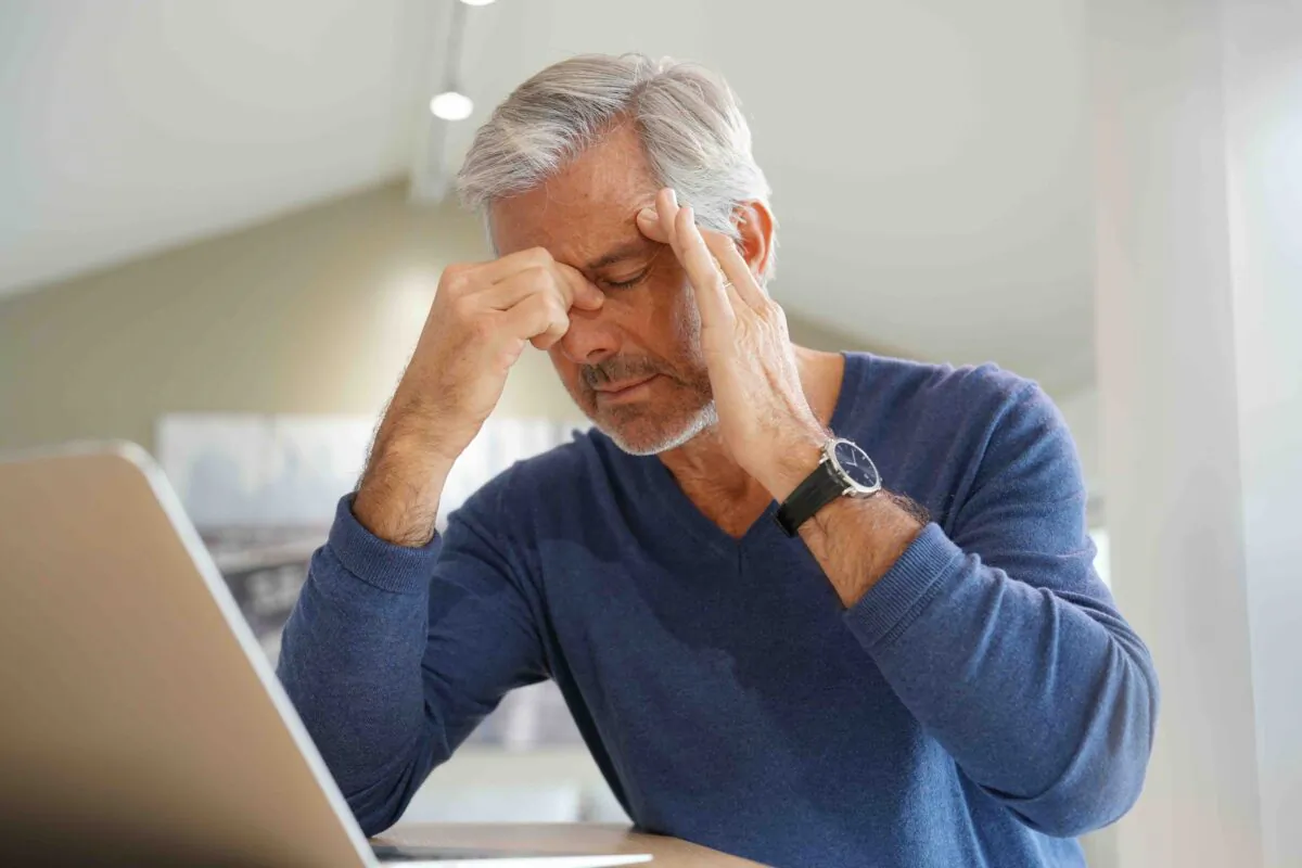 Senior man having a headache while working on laptop computer
(goodluz/Shutterstock)