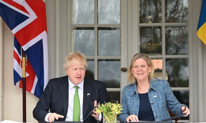 British Prime Minister Boris Johnson and Sweden's Prime Minister Magdalena Andersson exchange documents as they sign a declaration of political solidarity at the Swedish Prime Minister's summer residence in Harpsund, Sweden, on May 11, 2022. (Jonathan Nackstrand /AFP via Getty Images)