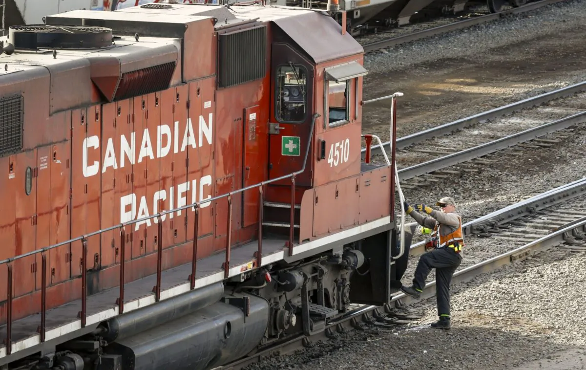 A worker boards a Canadian Pacific Railway locomotive at a yard in Calgary on March 18, 2022. (The Canadian Press/Jeff McIntosh)