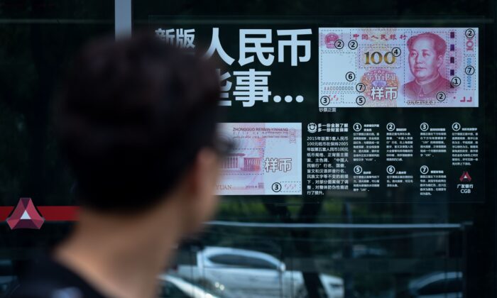 A man looks at information posted on a bank door showing how to distinguish counterfeit banknotes in Beijing on July 20, 2018. (Wang Zhao/AFP via Getty Images)