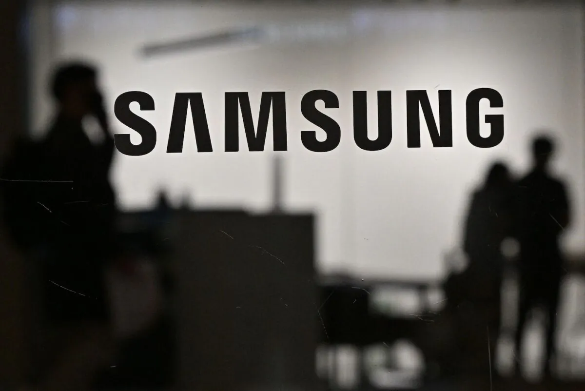 People walk past the Samsung logo displayed on a glass door at the company's Seocho building in Seoul on April 28, 2022. (Jung Yeon-je /AFP via Getty Images)