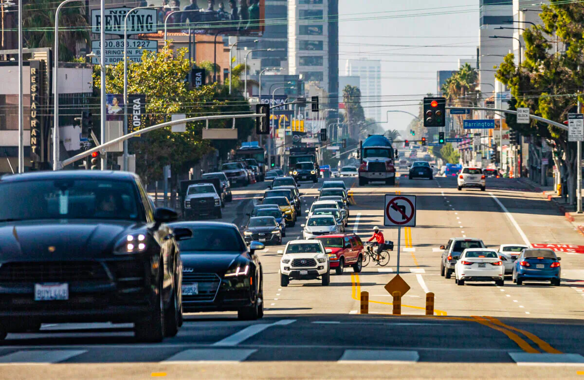 Cars and pedestrians travel in western Los Angeles on Nov. 10, 2021. (John Fredricks/The Epoch Times)