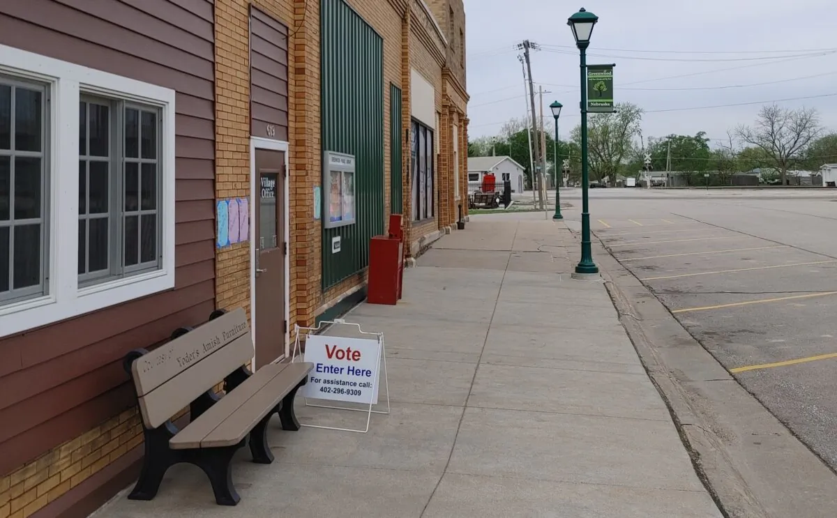 A sign directs voters to the polling place at the village office that also houses the library in the tiny village of Greenwood, Nebraska, for the primary election on May 10, 2022. (Jeff Louderback/The Epoch Times)