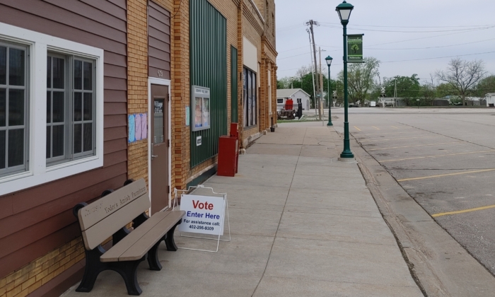 A sign directs voters to the polling place at the village office that also houses the library in the tiny village of Greenwood, Nebraska, for the primary election on May 10, 2022. (Jeff Louderback/The Epoch Times)