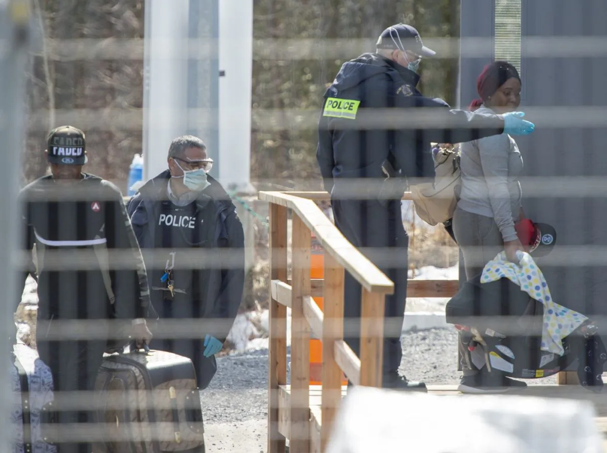 Asylum seekers cross the border from New York into Canada at Roxham Road, March 18, 2020, in Hemmingford, Que. (The Canadian Press/Ryan Remiorz)