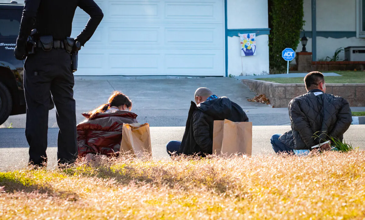 Men and women are taken into custody after being caught in an illegal gambling operation in Westminster, Calif., on May 10, 2022. (John Fredricks/The Epoch Times)