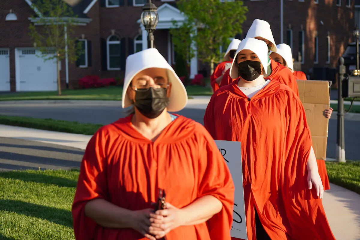 Pro-abortion "performative artists" walk in circles near Justice Amy Coney Barrett's house in Falls Church, Virginia on May 11, 2022 (Jackson Elliott/The Epoch Times)