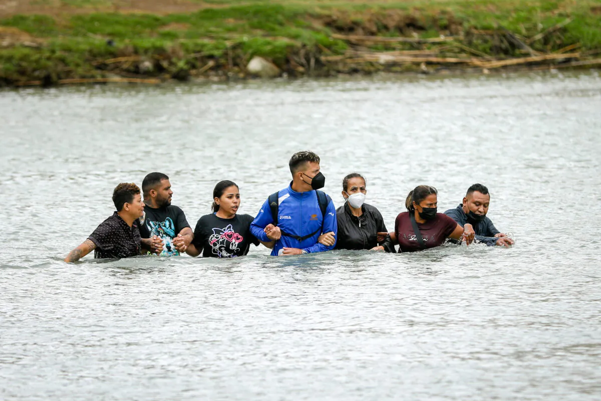 A group of Nicaraguans and Cubans crosses the Rio Grande from Mexico into Eagle Pass, Texas, on April 25, 2022. (Charlotte Cuthbertson/The Epoch Times)