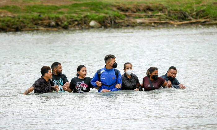 A group of Nicaraguans and Cubans crosses the Rio Grande from Mexico into Eagle Pass, Texas, on April 25, 2022. (Charlotte Cuthbertson/The Epoch Times)