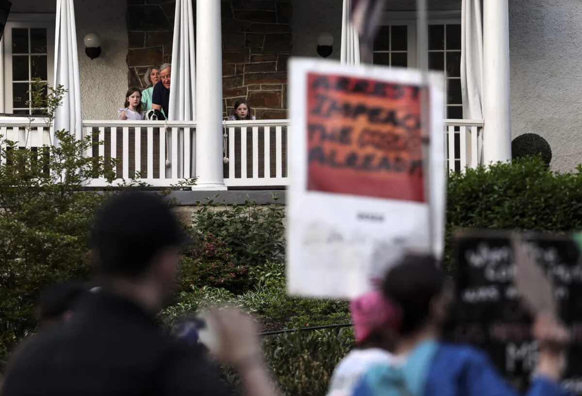 Residents watch as pro-abortion protesters march near the home of U.S. Supreme Court Chief Justice John Roberts in Chevy Chase, Maryland on May 11, 2022. (Kevin Dietsch/Getty Images)