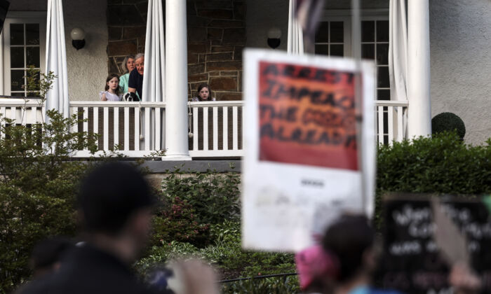 Residents watch as pro-abortion protesters march near the home of U.S. Supreme Court Chief Justice John Roberts in Chevy Chase, Maryland on May 11, 2022. (Kevin Dietsch/Getty Images)