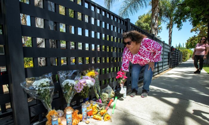 Places flowers at a memorial in front of a home on Victory Boulevard in West Hills, Lupeann Campos of Winnetka, Calif., on May 9, 2022. (Mel Melcon/Los Angeles Times/TNS)
