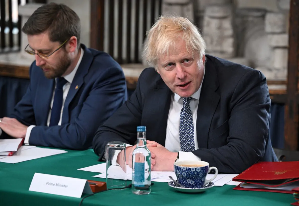 Britain's Prime Minister Boris Johnson (R), flanked by Britain's Cabinet Secretary and Head of the Civil Service Simon Case, chairs a Cabinet meeting at a pottery in Stoke-on-Trent, central England, on May 12, 2022. (Oli Scarff /Pool/AFP via Getty Images)