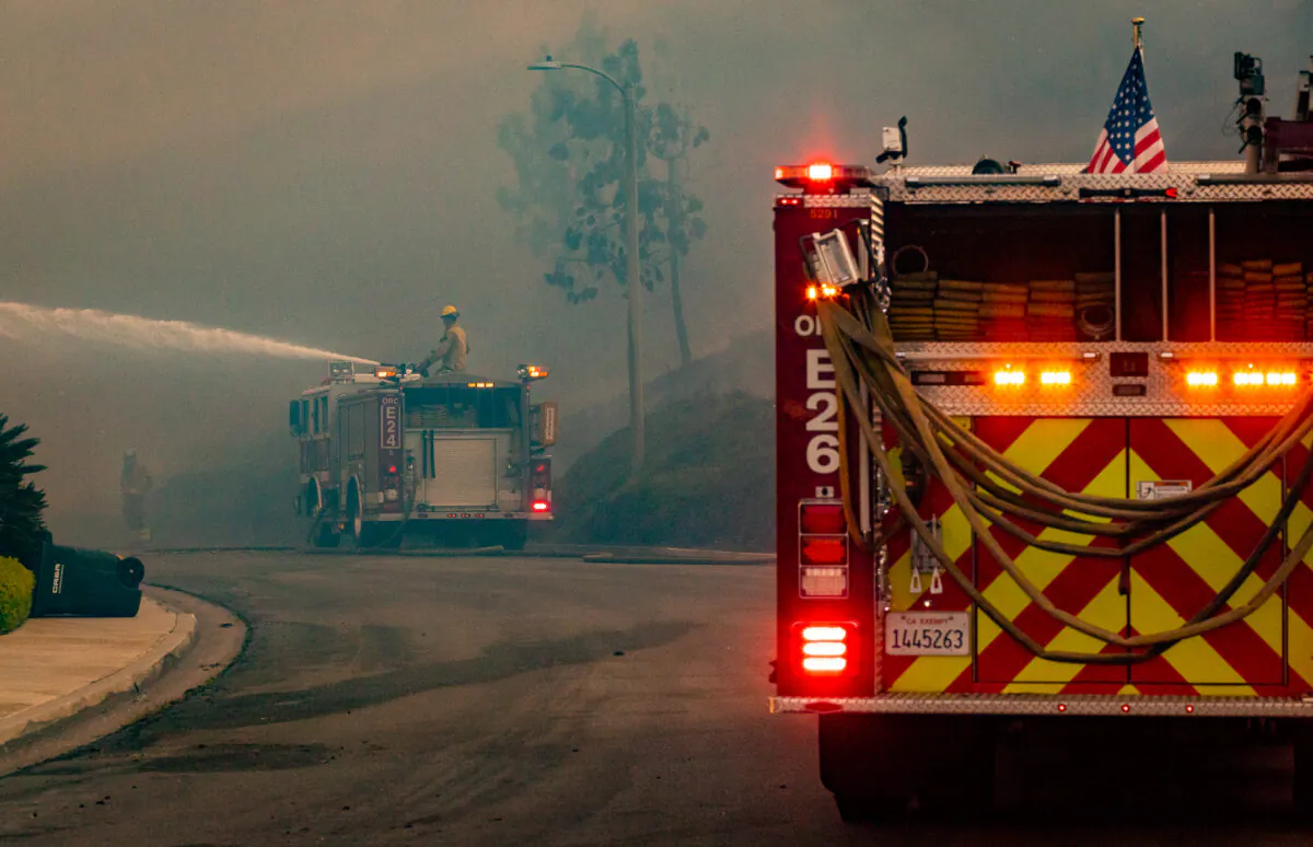 Firefighters work on extinguishing a fire on May. 11, 2022. (John Fredricks/The Epoch Times)