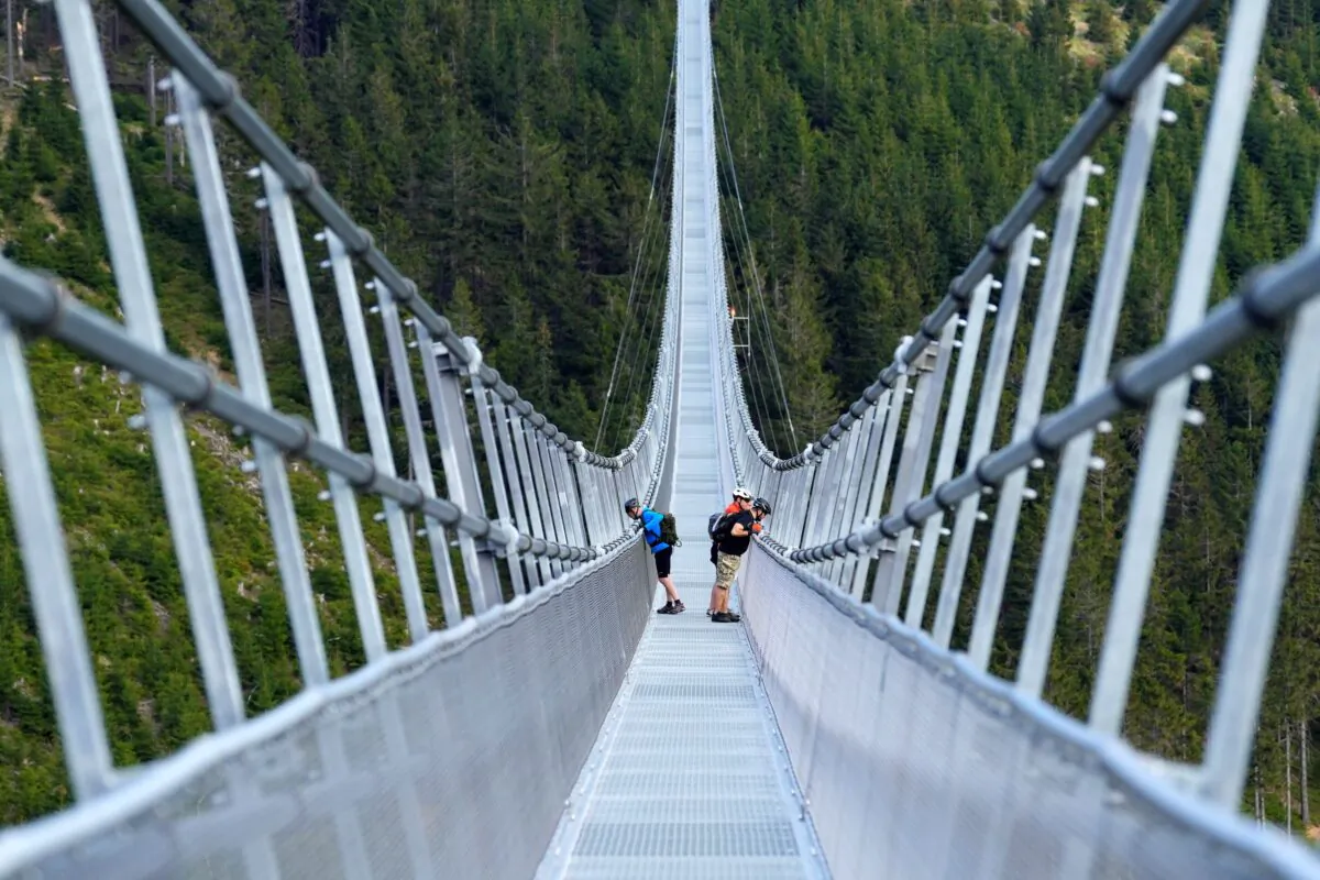 People stand on a suspension bridge for the pedestrians that is the longest such construction in the world a day before its official opening at a mountain resort in Dolni Morava, Czech Republic, on May 12, 2022. (Petr David Josek/AP Photo)