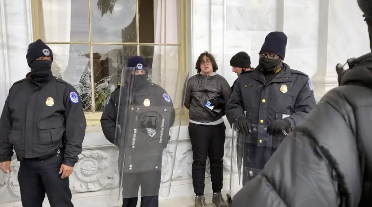 Hunter Ehmke, 21, is detained by police after smashing windows at the U.S. Capitol on Jan. 6, 2021. (©Bobby Powell, Truth is Viral/Screenshot via The Epoch Times)