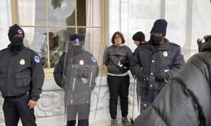 Hunter Ehmke, 21, is detained by police after smashing windows at the U.S. Capitol on Jan.  6, 2021. (©Bobby Powell, Truth is Viral/Screenshot via The Epoch Times)