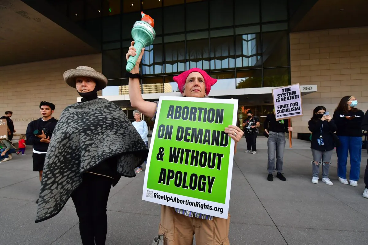 A protester holds the torch from Lady Liberty alongside other pro-abortion protesters gathered outside the U.S. Courthouse in downtown Los Angeles, Calif., on May 3, 2022. (Frederic J. Brown/AFP via Getty Images)