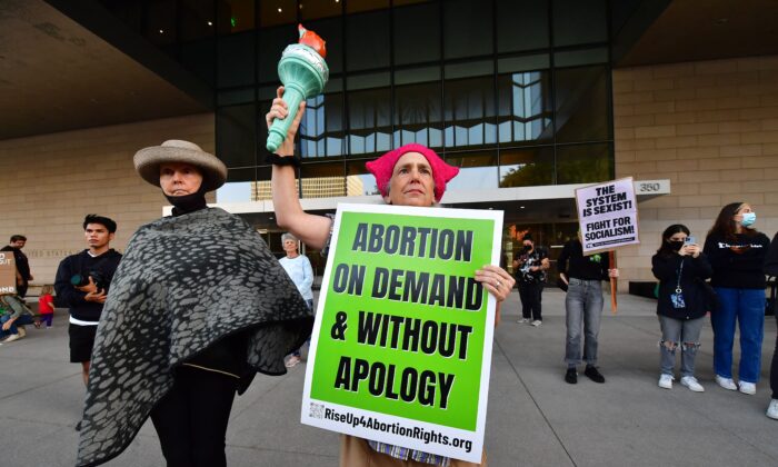 A protester holds the torch from Lady Liberty alongside other pro-abortion protesters gathered outside the U.S. Courthouse in downtown Los Angeles, Calif., on May 3, 2022. (Frederic J. Brown/AFP via Getty Images)