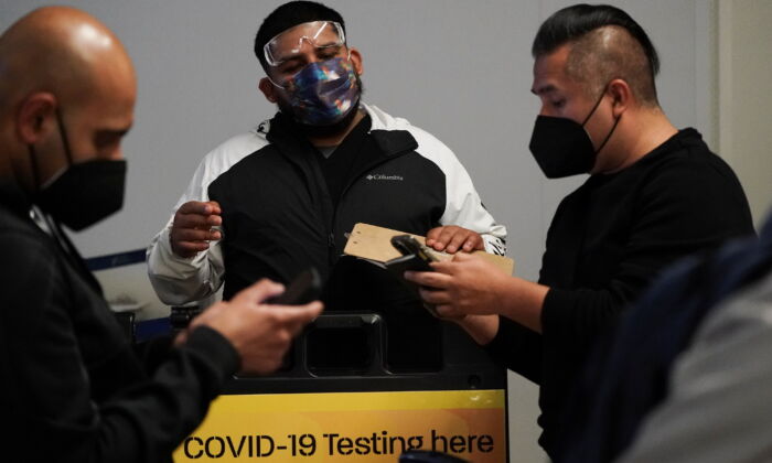 Travelers wait in line to get tests for the coronavirus disease (COVID-19) at a pop-up clinic at Tom Bradley International Terminal at Los Angeles International Airport, Calif., on Dec. 22, 2021. (Bing Guan/Reuters)