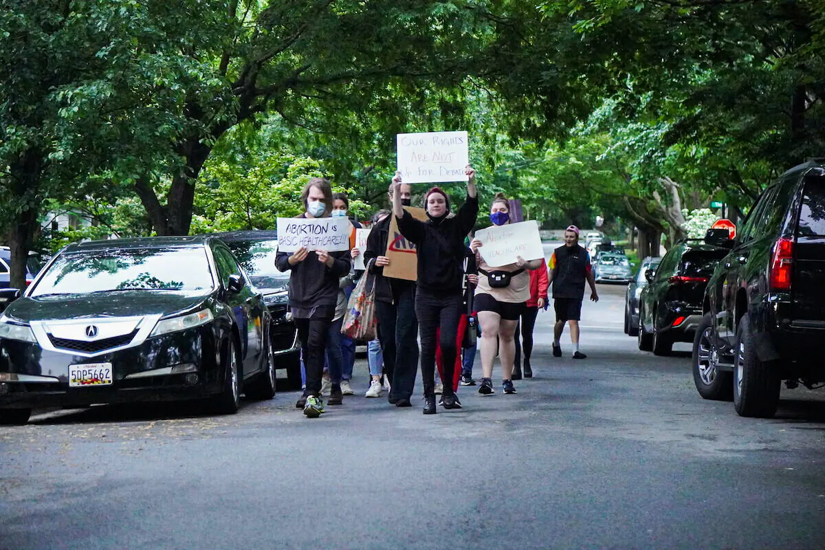 A column of 20 protesters marches through the neighborhood of Justice Brett Kavanaugh and Justice John Roberts in Chevy Chase, Maryland on May 15, 2022 (Jackson Elliott/The Epoch Times)