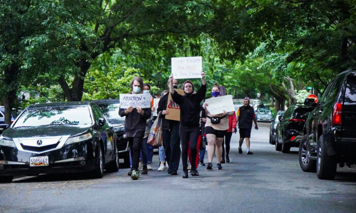 A column of 20 protesters marches through the neighborhood of Justice Brett Kavanaugh and Justice John Roberts in Chevy Chase, Maryland on May 15, 2022 (Jackson Elliott/The Epoch Times)