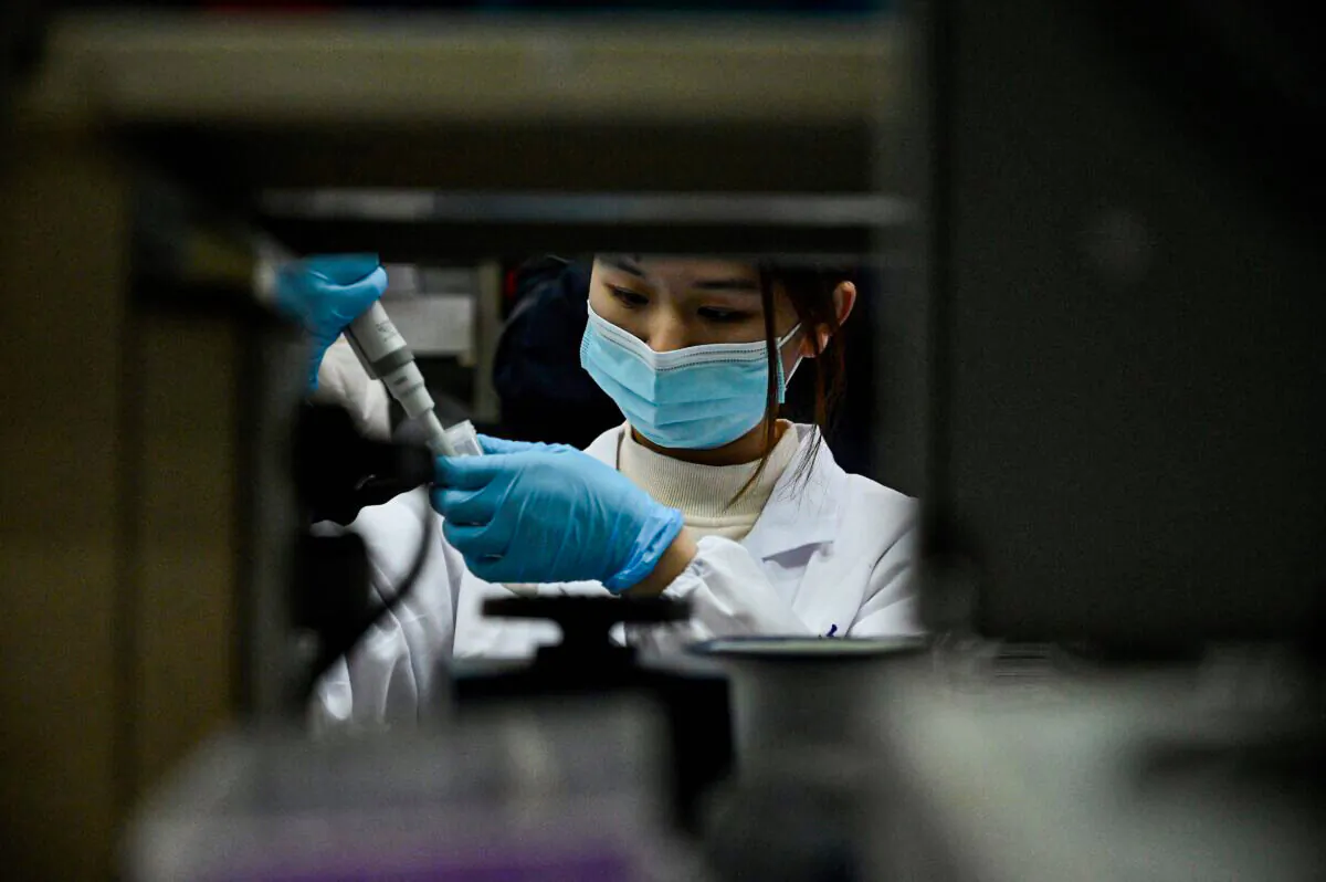 A laboratory technician works at a Tsinghua University lab in Beijing on Dec. 9, 2021. (Noel Celis/AFP via Getty Images)