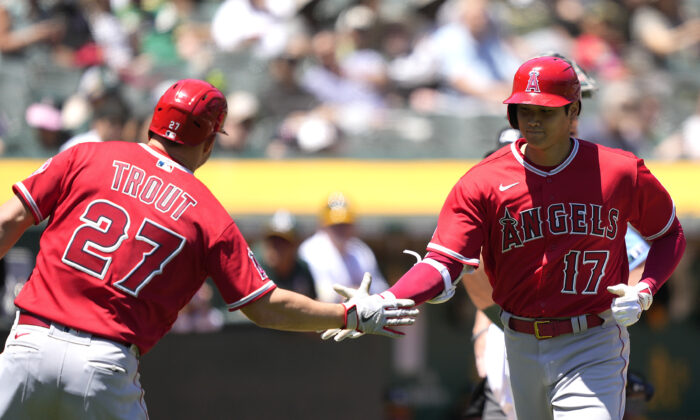 Shohei Ohtani #17 of the Los Angeles Angels is congratulated by third base coach Mike Trout #27 after Ohtani hit a two-run home run against the Oakland Athletics in the top of the firs inning at RingCentral Coliseum, in Oakland, Calif., on May 15, 2022. (Thearon W. Henderson/Getty Images)