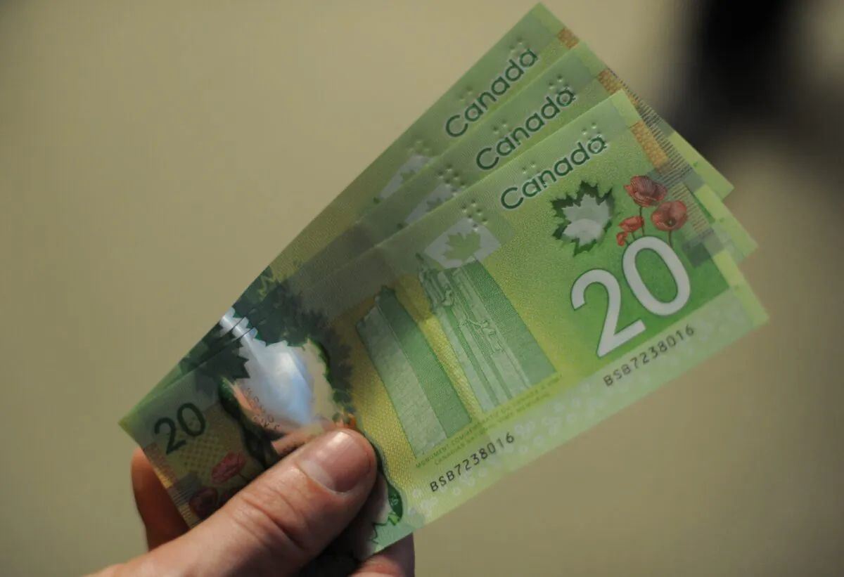 A man displays Canadian $20 bills in a file photo. (Nicholas Kamm/AFP via Getty Images)