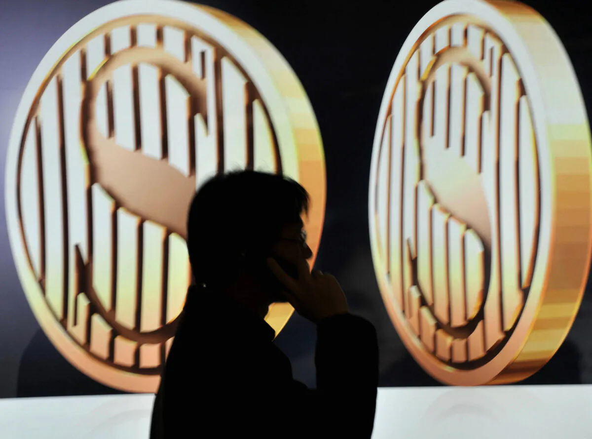 A man walks past a dollar sign in Hong Kong, on Jan. 31, 2008. (Ted Aljibe/AFP via Getty Images)