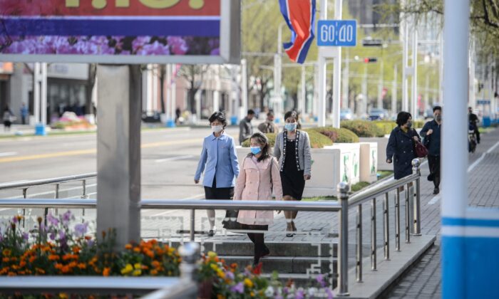 Pedestrians walk near a poster displayed to celebrate the 110th birth anniversary of the late North Korean leader Kim II Sung in Pyongyang on April 14, 2022. (KIM WON JIN/AFP via Getty Images)