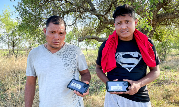 Two Nicaraguan nationals hold up the cell phones they received from Border Patrol before being released into the United States, in Kinney County, Texas, on April 29, 2022. (Charlotte Cuthbertson/The Epoch Times)