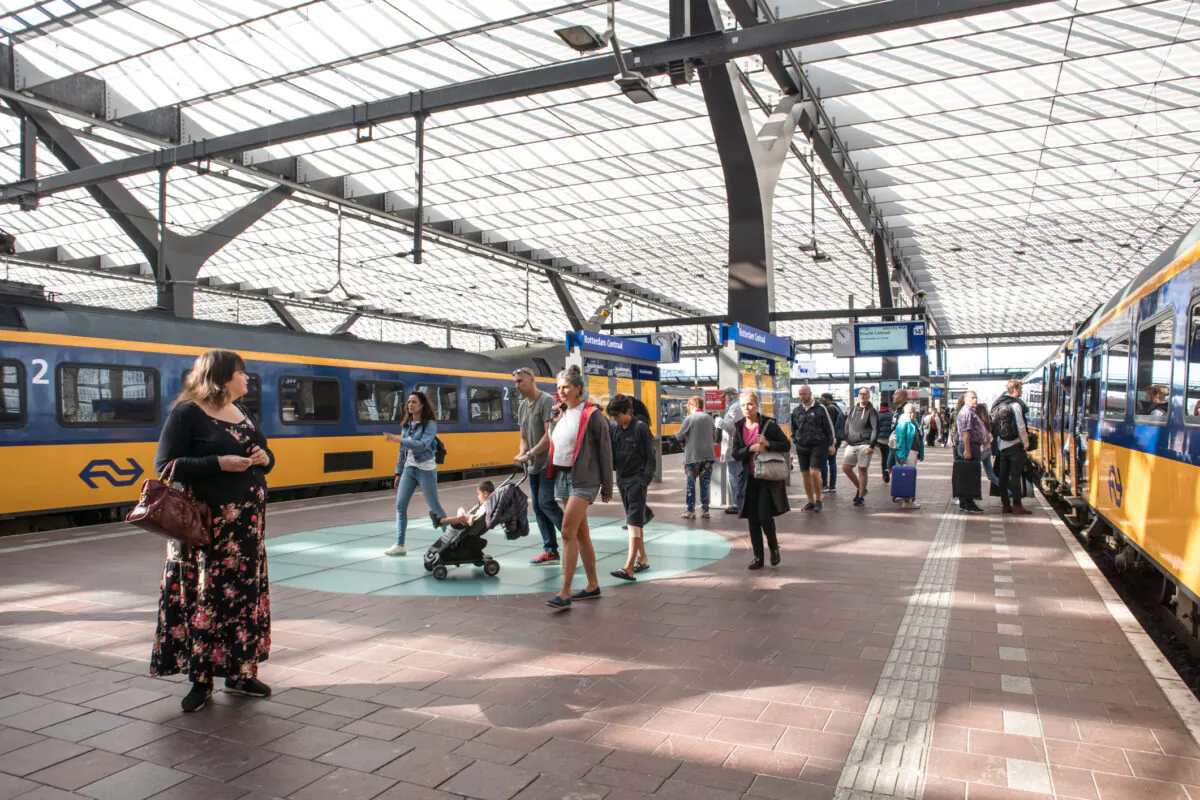 Rotterdam/Netherlands : People on a central platform of a railway station with trains on either side. (Dreamstime)
.
