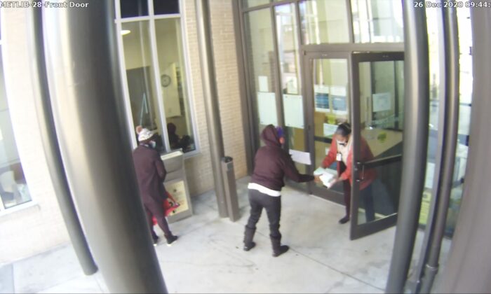 A still frame from surveillance footage of a ballot drop box at a library in Atlanta. True the Vote has officially asked Georgia officials to investigate the circumstances. Video seems to show ballots being passed between an election worker and an unknown library staffer. (Courtesy of True the Vote)