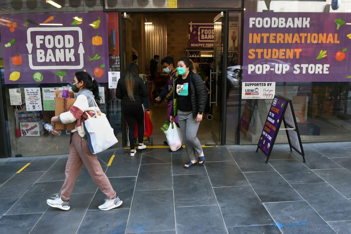 International students carry groceries from a foodbank in Melbourne, Australia on Aug. 13, 2021. (William West/AFP via Getty Images)