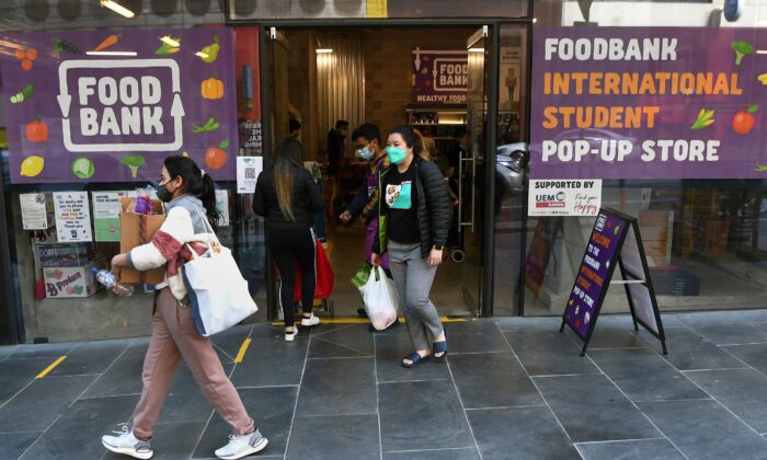 International students carry groceries from a foodbank in Melbourne, Australia on Aug. 13, 2021. (William West/AFP via Getty Images)