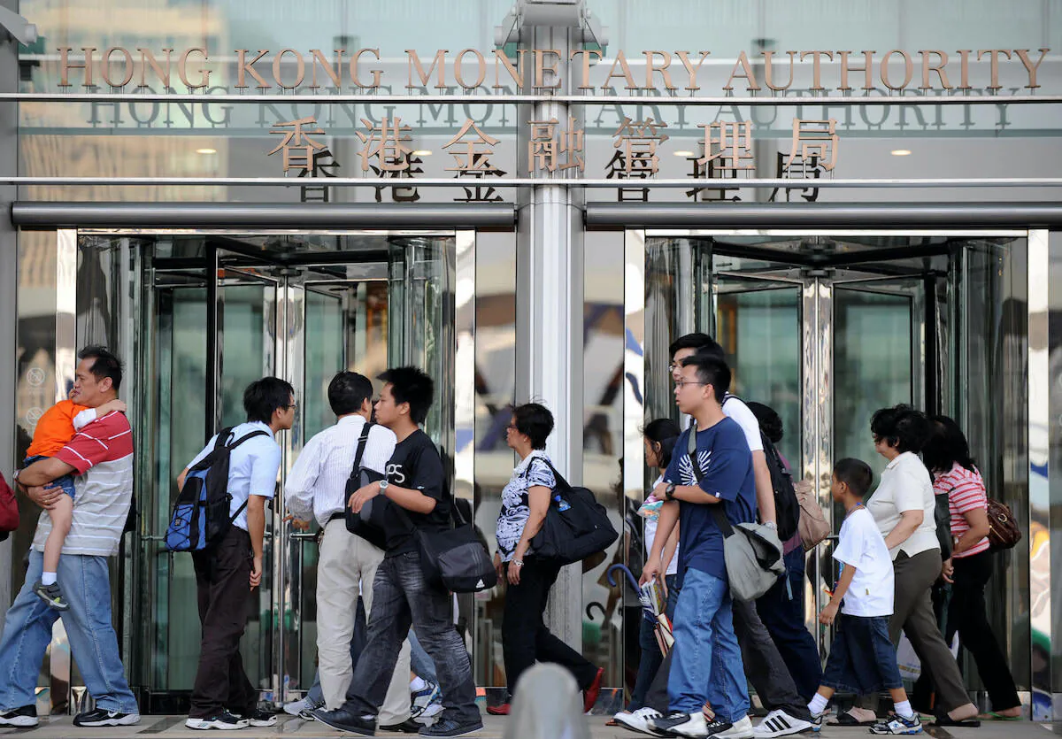 Pedestrians walk past the building housing the Hong Kong Monetary Authority's office on Oct. 24, 2008. (Ted Aljibe/AFP via Getty Images)
