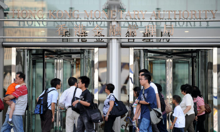 Pedestrians walk past the building housing the Hong Kong Monetary Authority's office on Oct. 24, 2008. (Ted Aljibe/AFP via Getty Images)