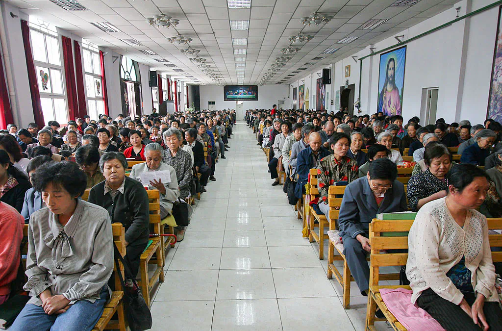 Christians pray during a mass at a church in Xining, Qinghai Province, northwest China, on July 3, 2005. China officially sanctions five religious groups: Protestant and Catholic Christianity, Islam, Buddhism, and Taoism. Chinese are allowed to worship only in state-sanctioned churches and temples. (China Photos/Getty Images)