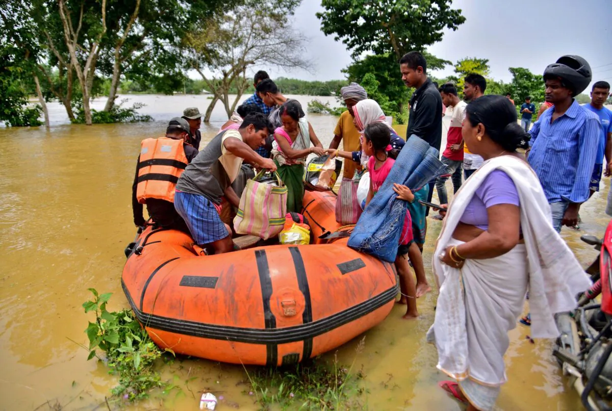 People disembark a boat after they were evacuated from a flooded village in Nagaon district, in the northeastern state of Assam, India, on May 18, 2022. (Anuwar Hazarika/Reuters)