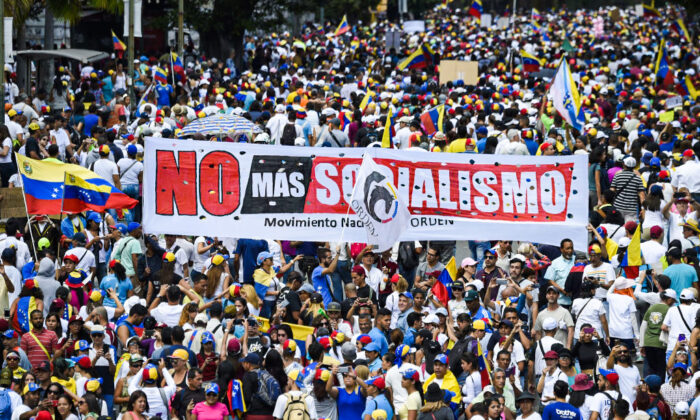 Opposition supporters hold a banner reading "No More Socialism" during a gathering with Venezuelan opposition leader Juan Guaido, in Caracas, on Feb. 2, 2019. Guaido called for early elections as international pressure increased on President Nicolas Maduro to step down. (Juan Barreto/AFP via Getty Images)