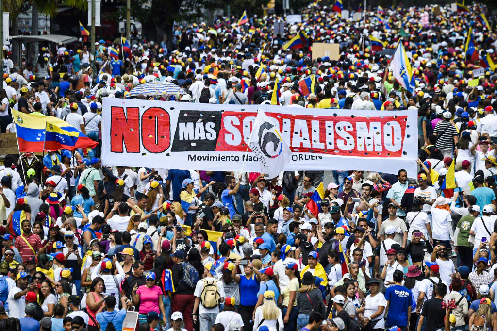 Opposition supporters hold a banner reading "No More Socialism" during a gathering with Venezuelan opposition leader Juan Guaido, in Caracas, on Feb. 2, 2019. Guaido called for early elections as international pressure increased on President Nicolas Maduro to step down. (Juan Barreto/AFP via Getty Images)
