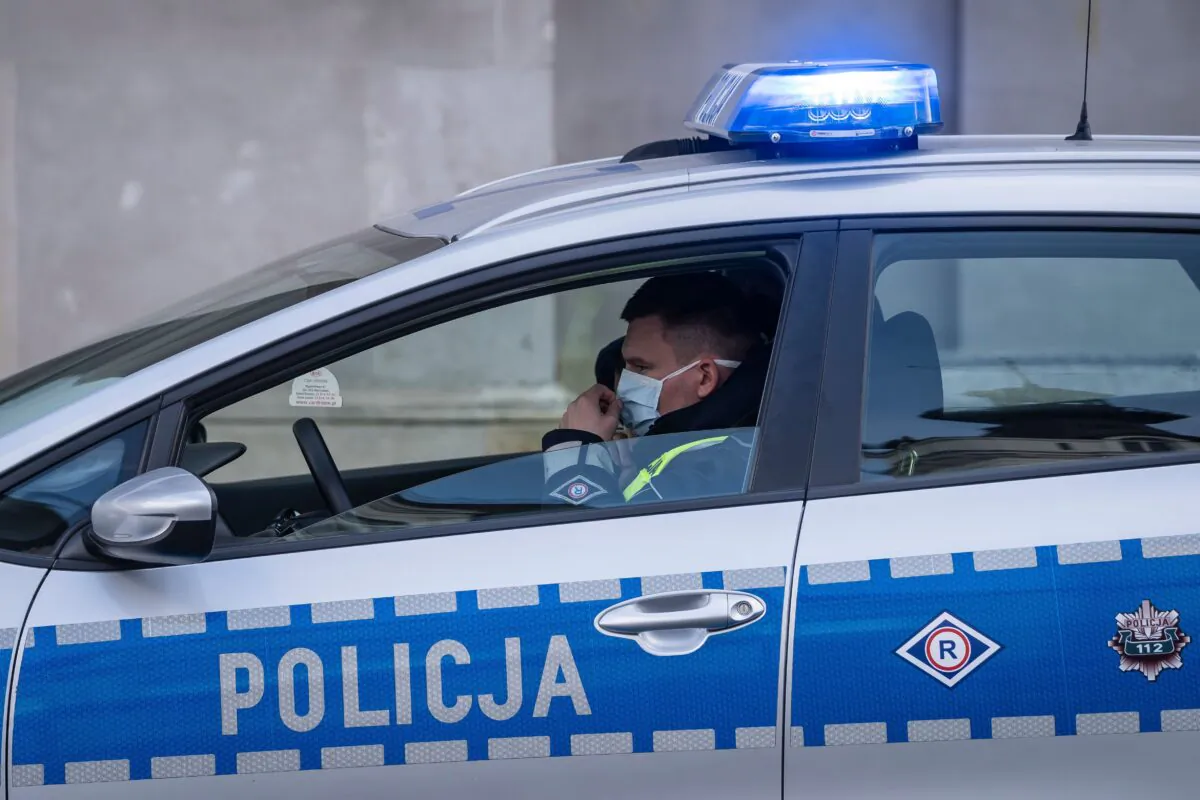 A police officer wearing a face mask patrols in his car during a protest by a few dozens of entrepreneurs in the center of Warsaw, Poland, on March 31, 2020. (Wojtek Radawanski/AFP via Getty Images)