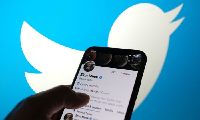 Elon Musk's Twitter account with a Twitter logo in the background in Los Angeles, Calif., on May 13, 2022. (Chris Delmas/AFP via Getty Images)