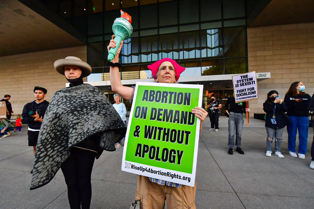 A protester holds the torch from Lady Liberty alongside other pro-abortion protesters gathered outside the U.S. Courthouse in downtown Los Angeles, Calif., on May 3, 2022. (Frederic J. Brown/AFP via Getty Images)