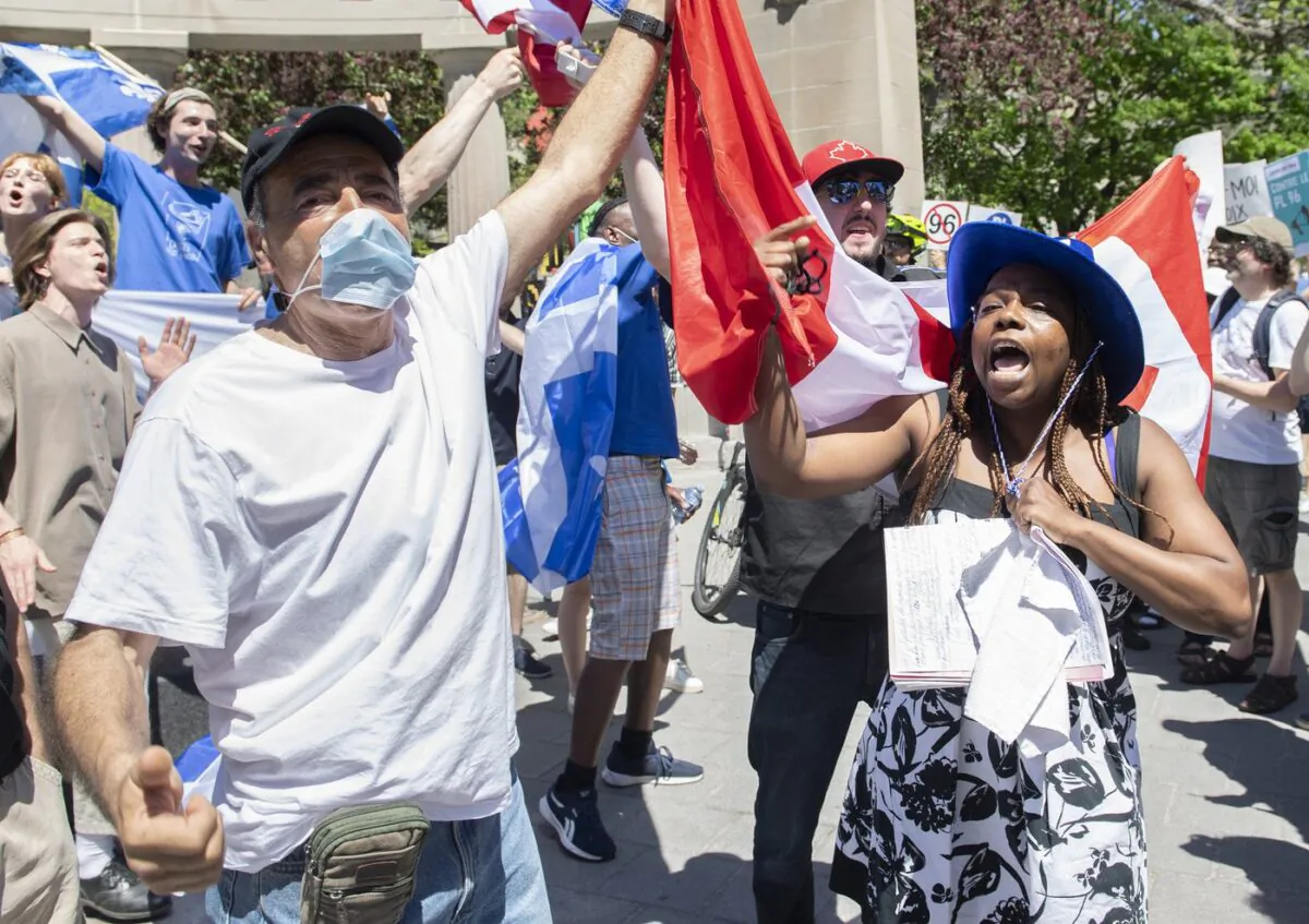 Anti-Bill 96 protesters hold up a Canadian flag as a Bill 96 supporter shouts during a demonstration in Montreal, May 14, 2022. (The Canadian Press/Graham Hughes)