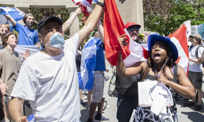 Anti-Bill 96 protesters hold up a Canadian flag as a Bill 96 supporter shouts during a demonstration in Montreal, May 14, 2022. (The Canadian Press/Graham Hughes)
