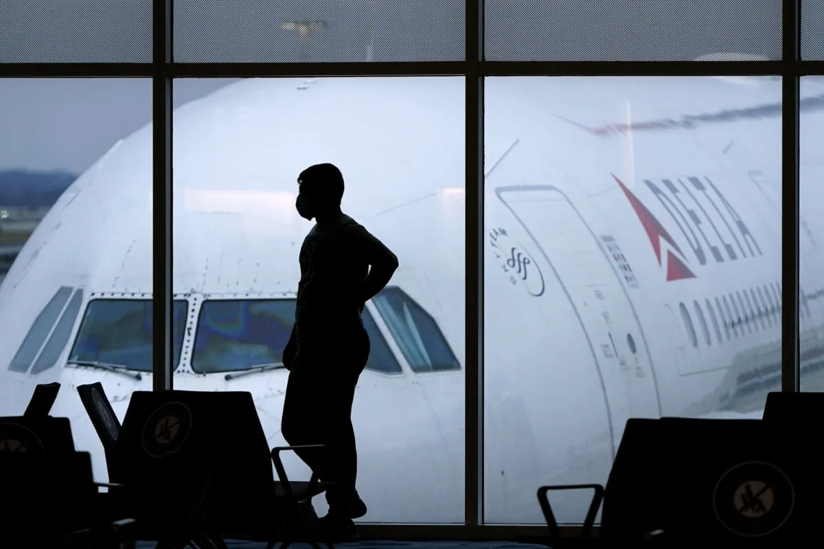 A passenger wears a mask as he waits for a Delta Airlines flight at Hartsfield-Jackson International Airport in Atlanta on Feb. 18, 2021. (Charlie Riedel, File/AP Photo)